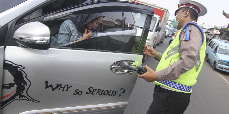 Petugas kepolisian menghentikan pengendara yang tidak mengikuti aturan PSBB, photo: antara